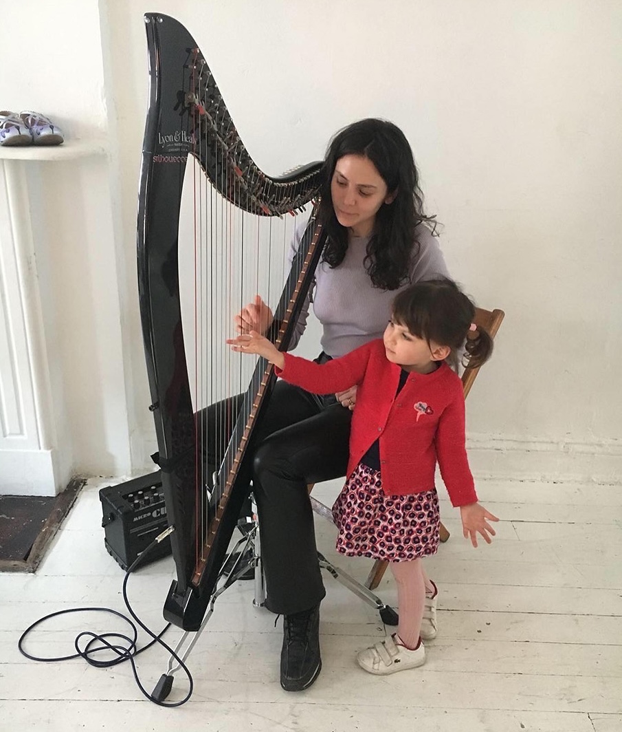 Esther teaching the harp to young girl.